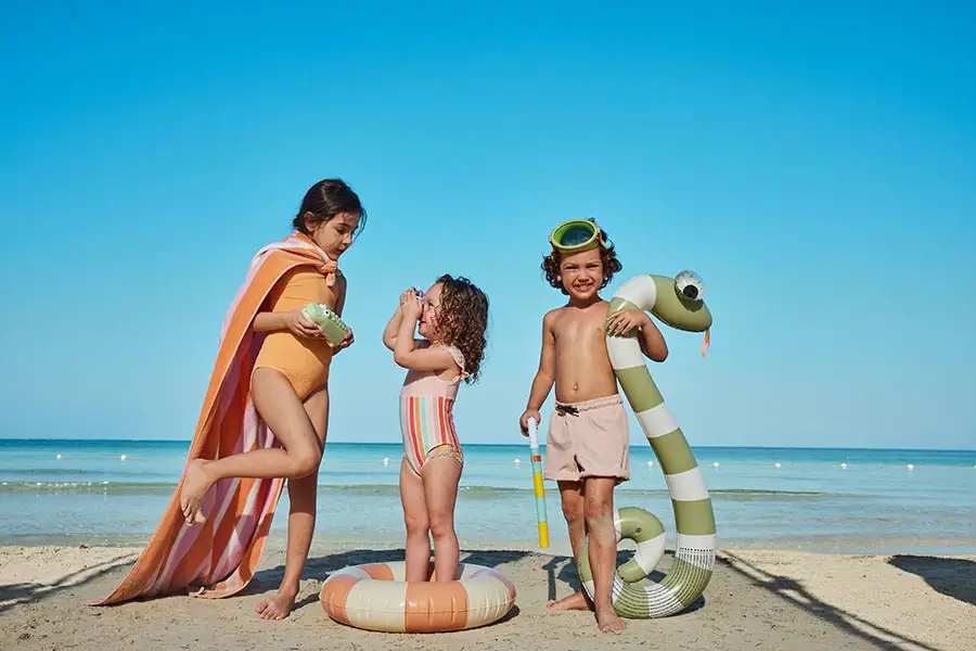 Family with kids in beach floats and snorkel gear at Beaches Exuma