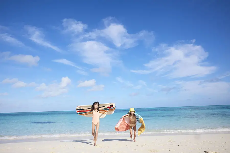 Two women running on the beach at Beaches Exuma