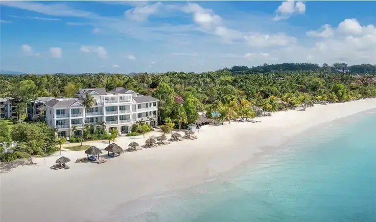 Aerial view of oceanfront building with beach umbrellas at Beaches Negril