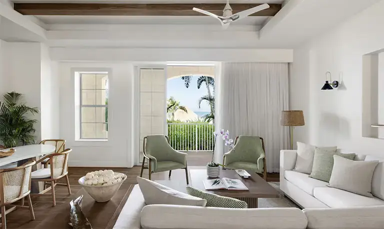 Bright suite living area with green accent chairs at Beaches Negril