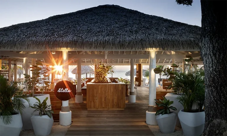 Thatched-roof restaurant at Beaches Negril at dusk