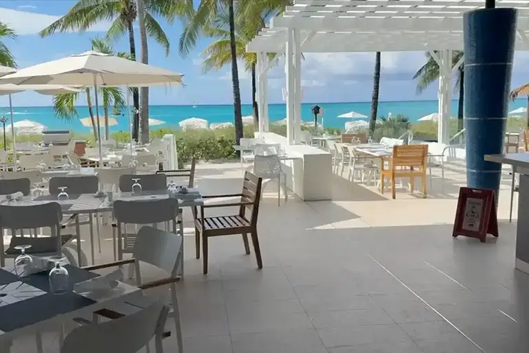 Oceanfront dining terrace with umbrella seating at Beaches Turks & Caicos