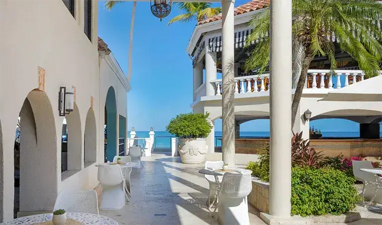 Mediterranean-style walkway with white archways at Sandals Grande Antigua
