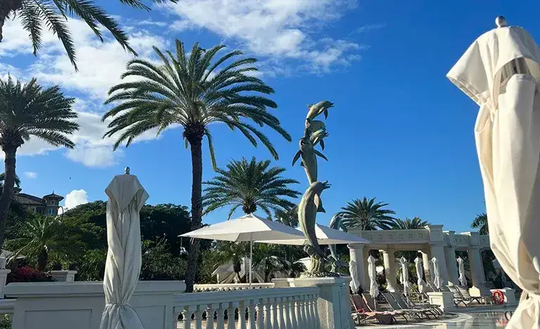 Pool area with dolphin fountain statue at Sandals Grande Antigua