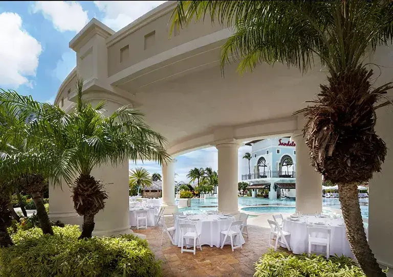 Poolside dining setup under Mediterranean arches at Sandals Grande Antigua