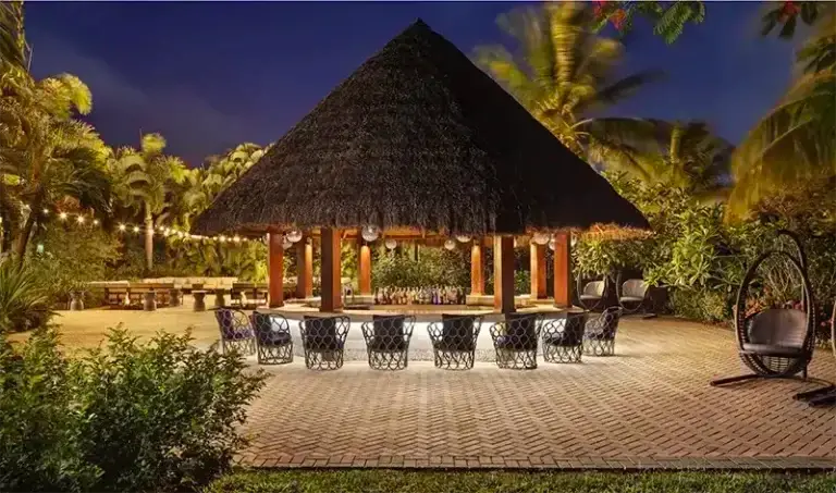 Thatched-roof lounge bar at night at Sandals Grande St. Lucian