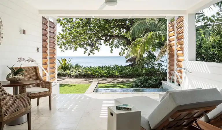Beachfront villa patio with pool and lounge chair at Sandals Halcyon Beach