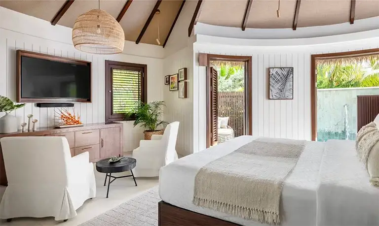 Bedroom with doors opening to pool view at Sandals Halcyon Beach
