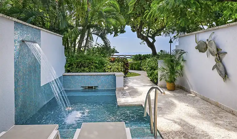 Multi-level resort pool surrounded by palm trees at Sandals Halcyon Beach