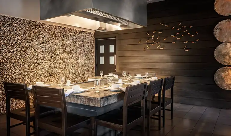Private dining room with stone wall accents at Sandals Halcyon Beach