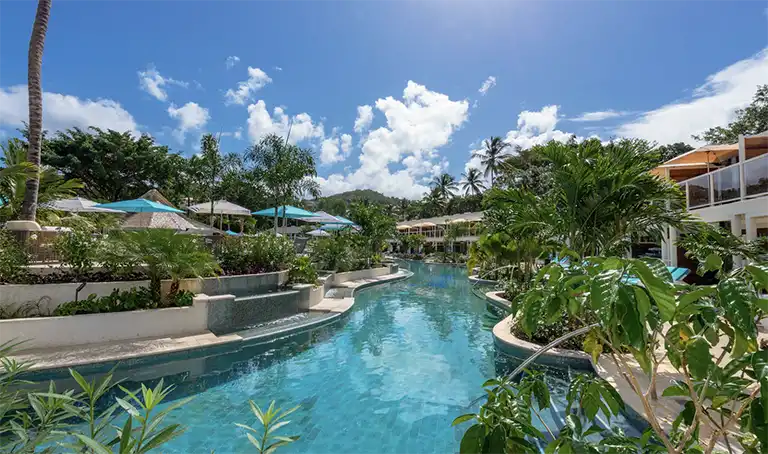 Resort pool area with palm trees at Sandals Halcyon Beach