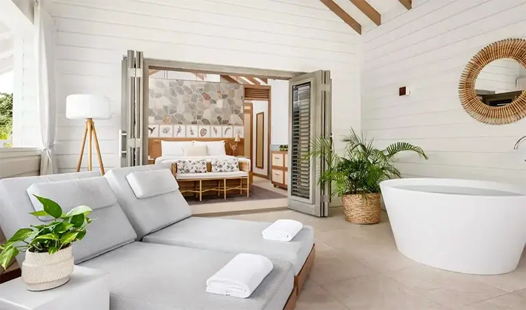 Suite bedroom with freestanding soaking tub at Sandals Halcyon Beach