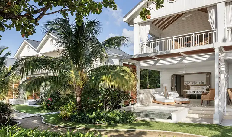 Two-story villa exterior with tropical garden at Sandals Halcyon Beach