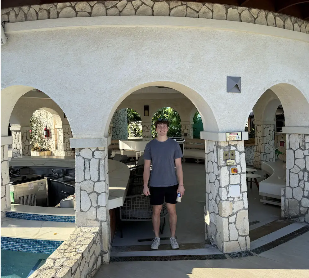 Guest standing in a stone courtyard surrounded by archways at Sandals Montego Bay
