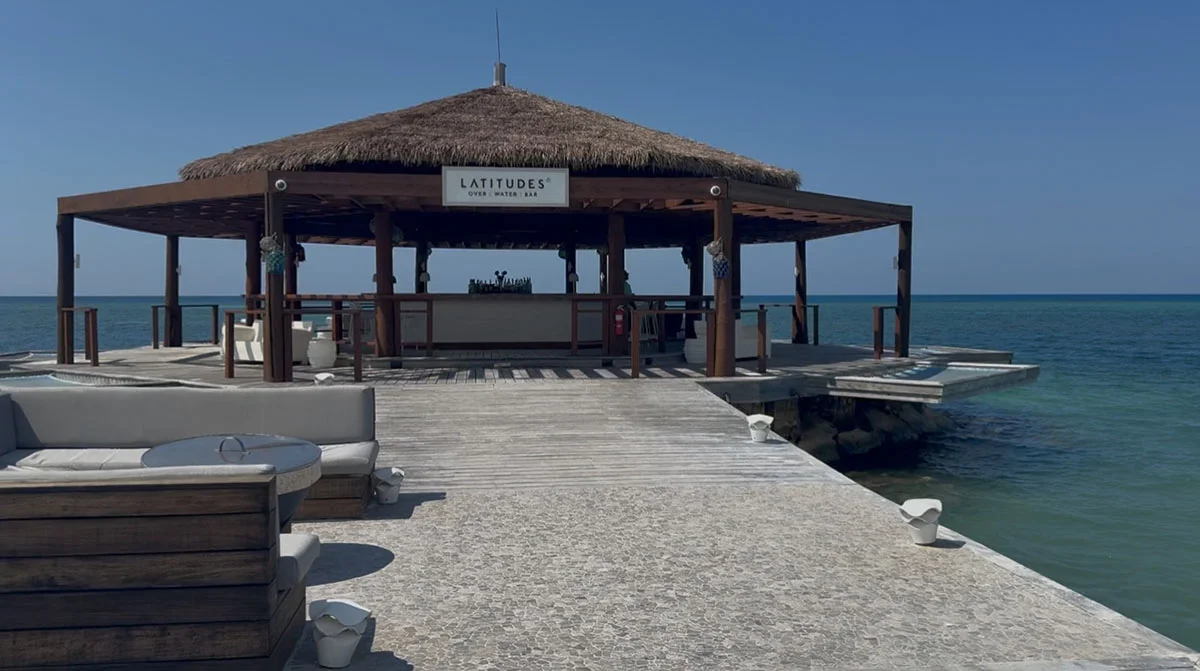 Wooden gazebo pavilion at the end of a stone pier over turquoise water at Sandals Montego Bay
