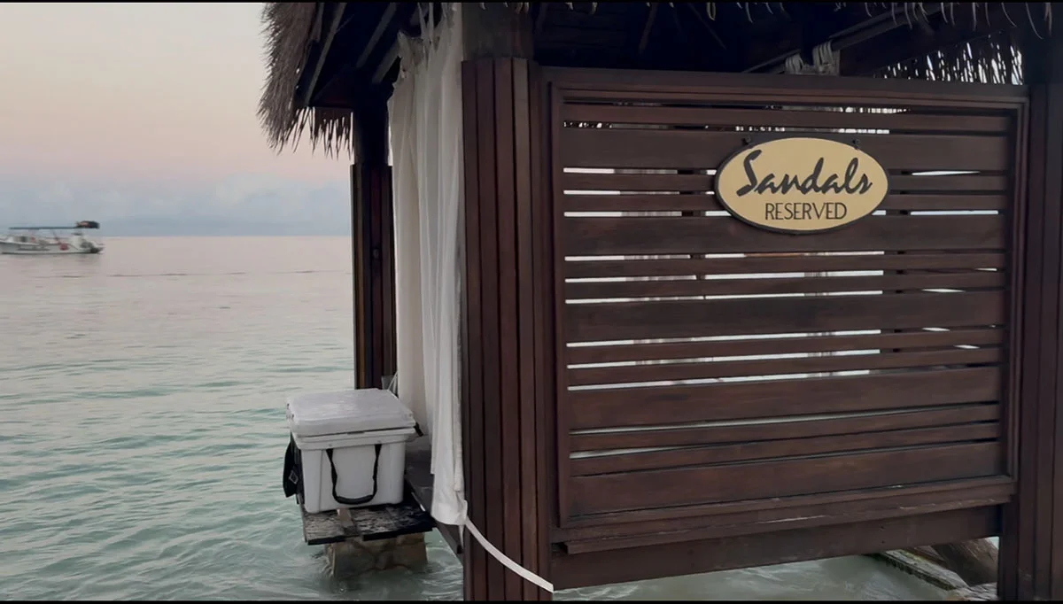 Over-the-water cabana with Sandals Reserved sign at sunset at Sandals Montego Bay