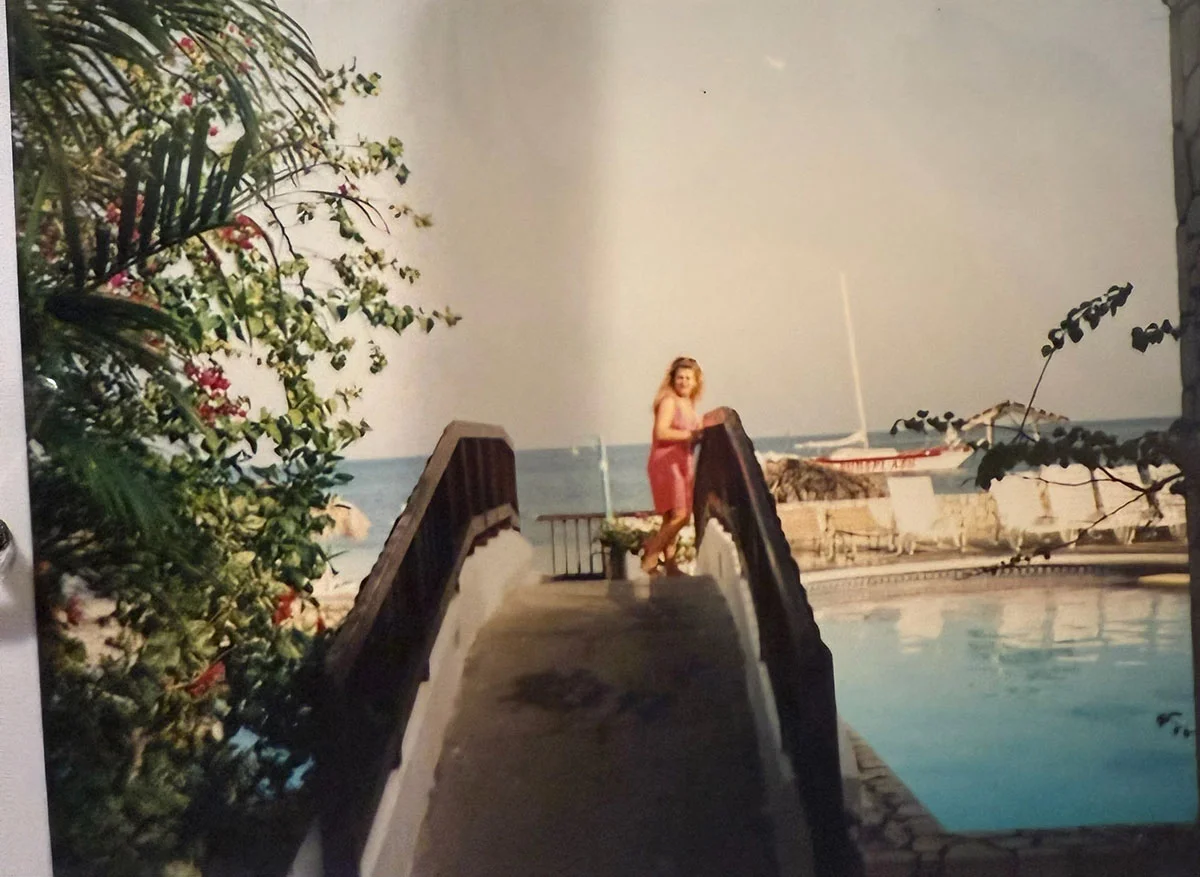 Guest standing on a wooden bridge over the pool with ocean views at Sandals Montego Bay