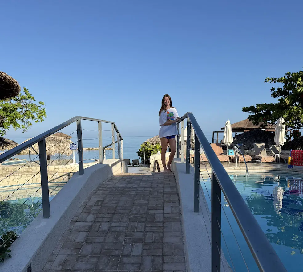 Guest walking across a stone bridge over the pool at Sandals Montego Bay