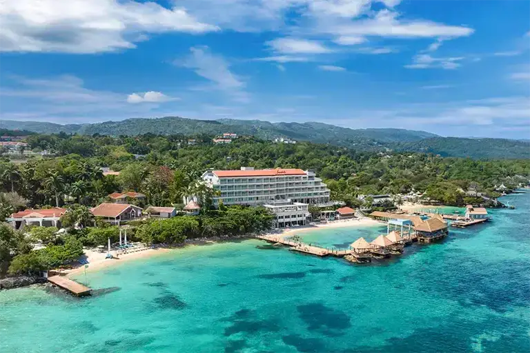 Aerial view of overwater pier and beach at Sandals Ochi Beach Resort, Jamaica