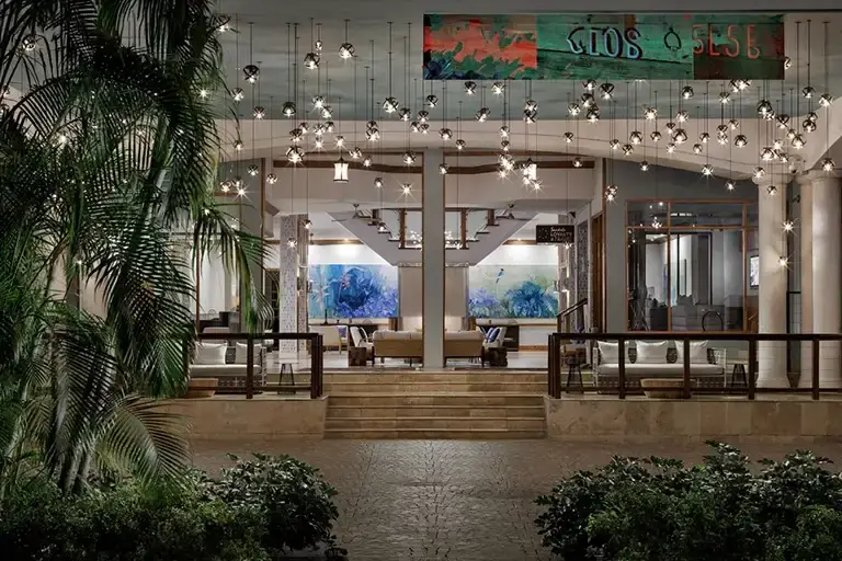 Outdoor lounge with string lights and palm trees at night at Sandals Ochi Beach Resort