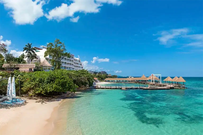 Sandals Ochi Rios overwater bungalows and pier with turquoise water and beach