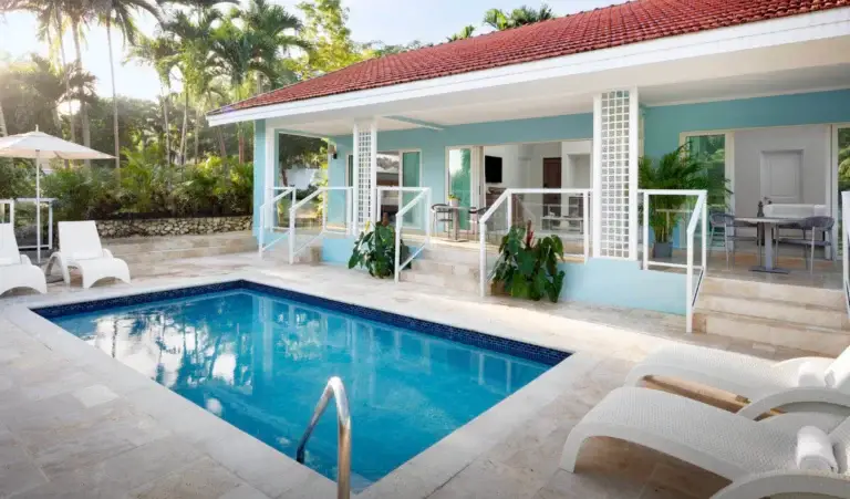 Private pool villa exterior with blue shutters and lounge chairs at Sandals Ochi Rios