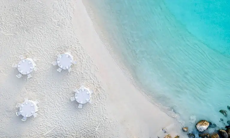 Aerial drone view of white beach umbrellas at Sandals Royal Bahamian