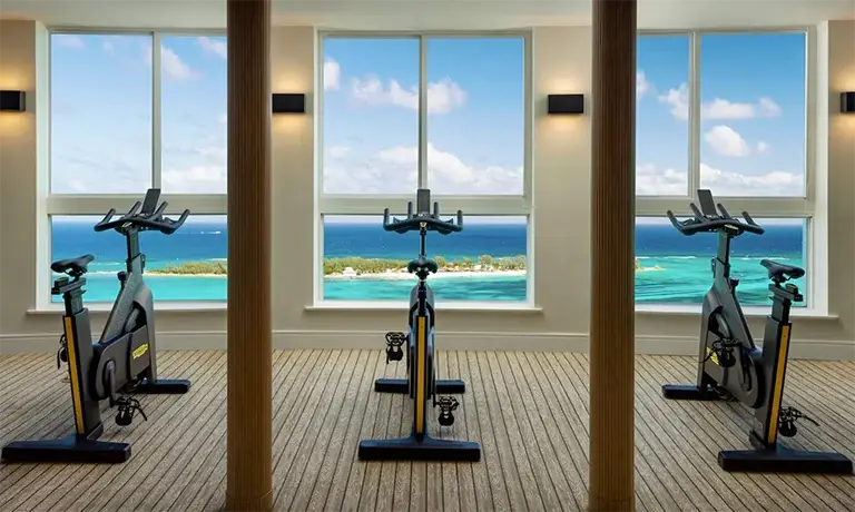 Fitness center with cardio bikes overlooking the ocean at Sandals Royal Bahamian