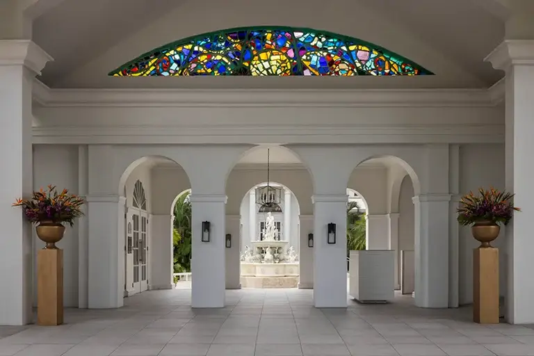 Grand entrance with stained glass window and arches at Sandals Royal Bahamian