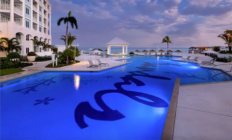 Blue lagoon pool with resort logo and beachfront gazebo at Sandals Royal Bahamian