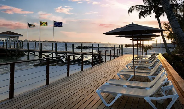 Sunset view from the pier with lounge chairs at Sandals Royal Bahamian, Nassau