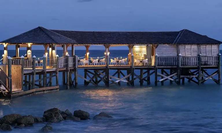 Overwater wedding gazebo pier lit up at dusk at Sandals Royal Bahamian