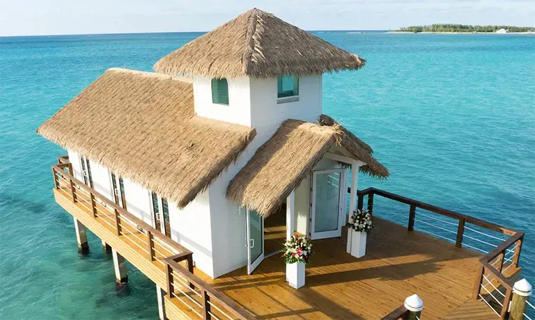 Overwater thatched-roof wedding gazebo at Sandals Royal Bahamian