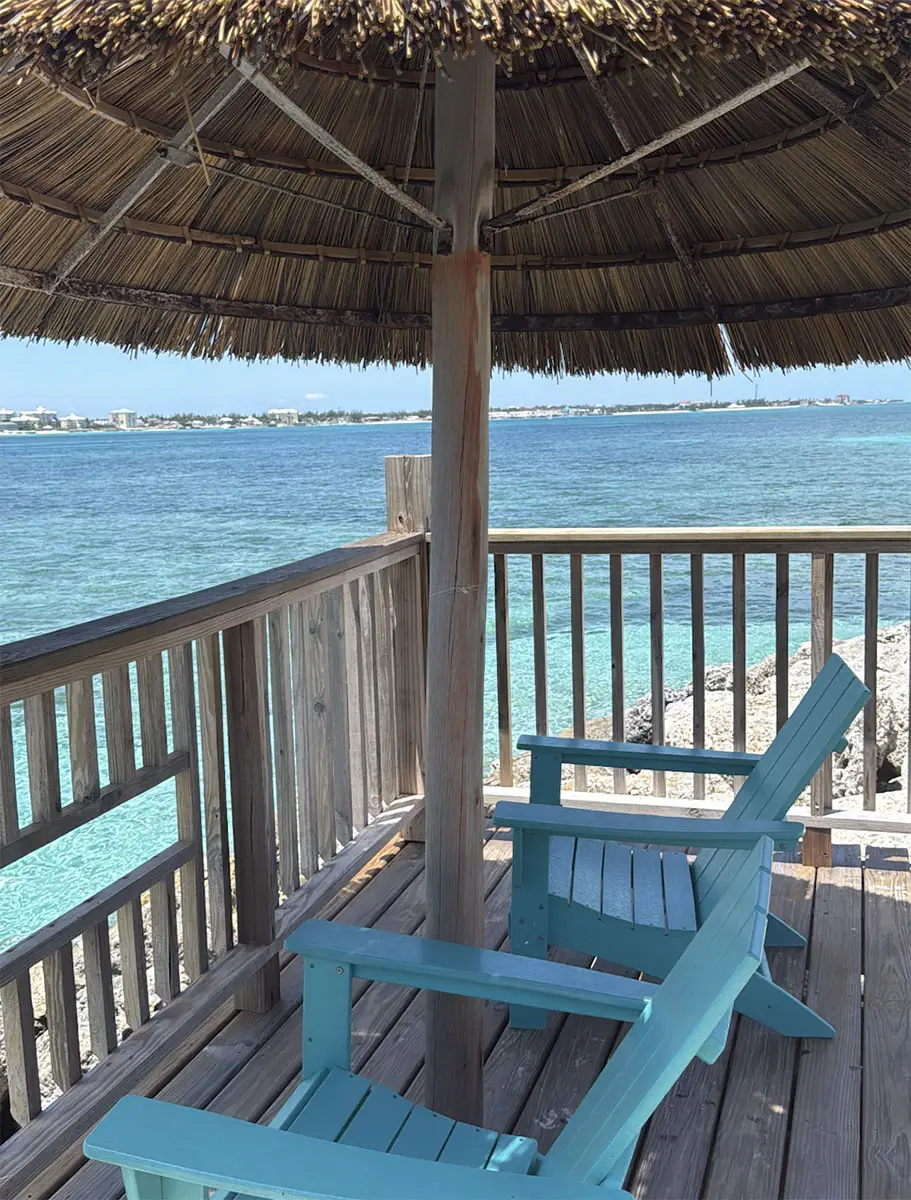 Pool deck view with palm trees and loungers at Sandals Royal Bahamian