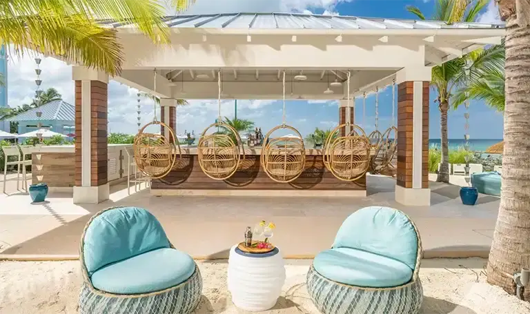 Poolside lounge cabana with turquoise chairs at Sandals Royal Bahamian