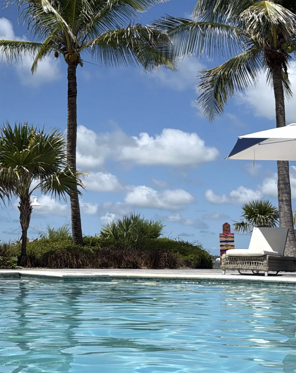 Poolside lounge area with palm trees at Sandals Royal Bahamian