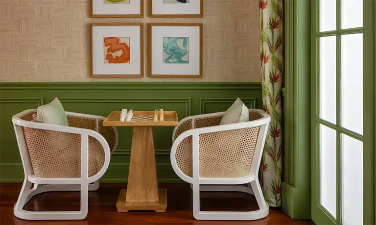 Cozy reading nook with rattan chairs and a round table at Sandals Royal Bahamian