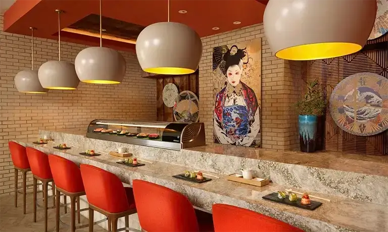 Modern sushi and hibachi bar with red stools at Sandals Royal Bahamian