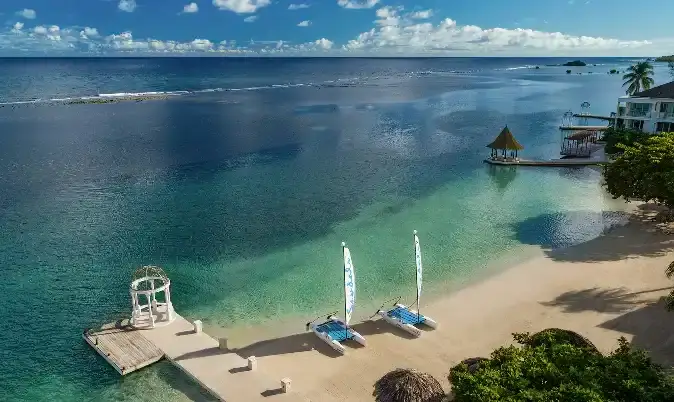 Aerial view of a beach dock with catamarans at Sandals Royal Caribbean