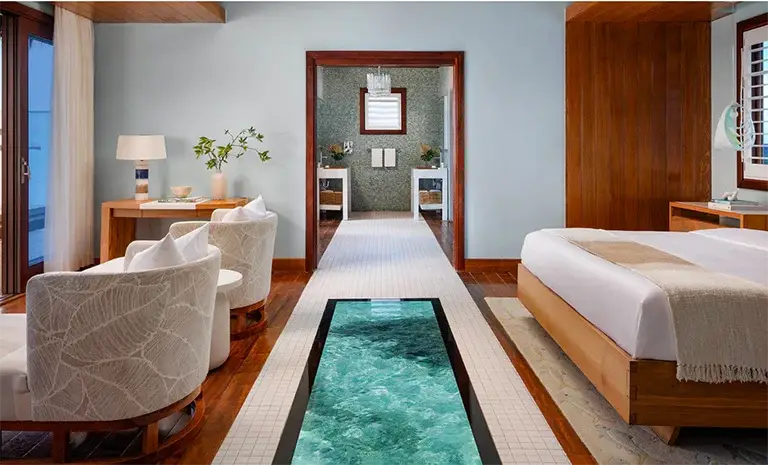 Suite bedroom with glass floor panel over the ocean at Sandals Royal Caribbean