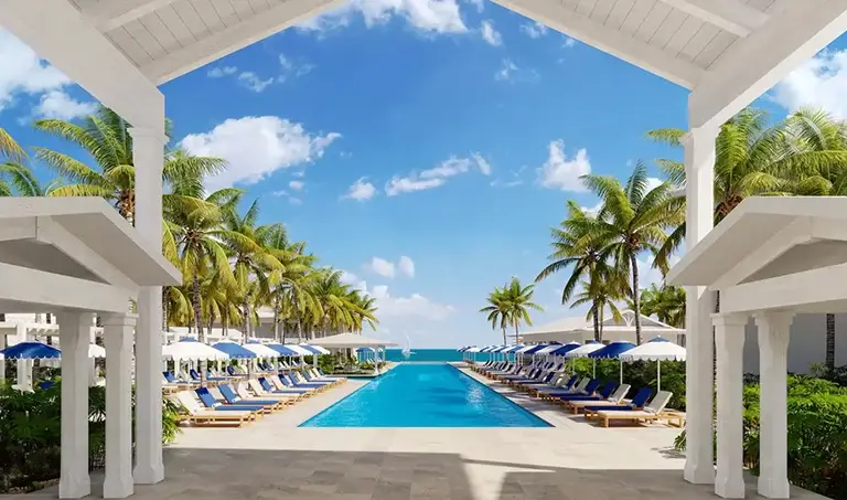 Palm-lined oceanfront pool with loungers at Sandals Royal Caribbean