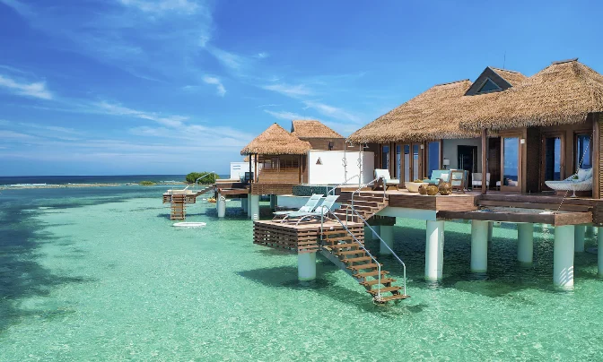 Overwater bungalows with private steps into turquoise water at Sandals Royal Caribbean