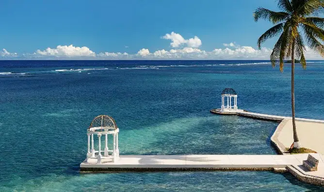 Twin gazebos on piers over turquoise ocean water at Sandals Royal Caribbean