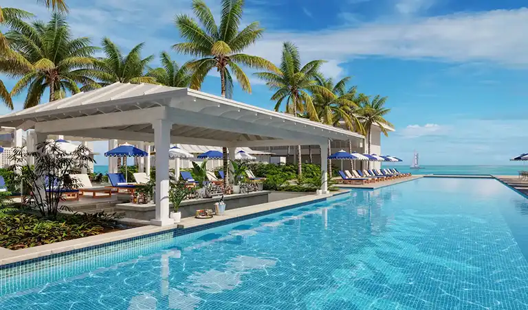 Poolside swim-up bar surrounded by palm trees and ocean view at Sandals Royal Caribbean