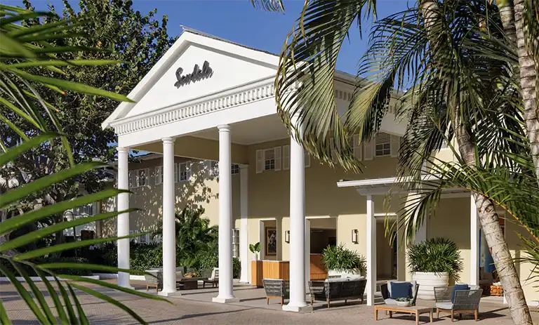 Columned entrance to Sandals Royal Caribbean resort surrounded by palm trees