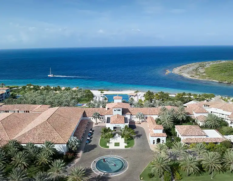Aerial view of the resort entrance and ocean at Sandals Royal Curacao