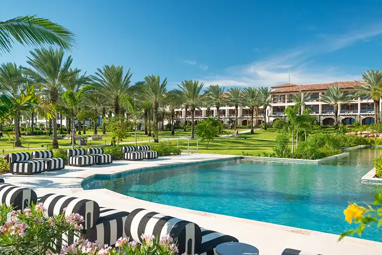 Royal Palms pool surrounded by palm trees at Sandals Royal Curacao
