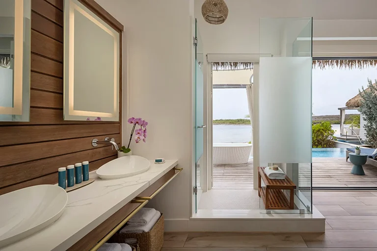 Suite bathroom opening onto a private patio at Sandals Royal Curacao