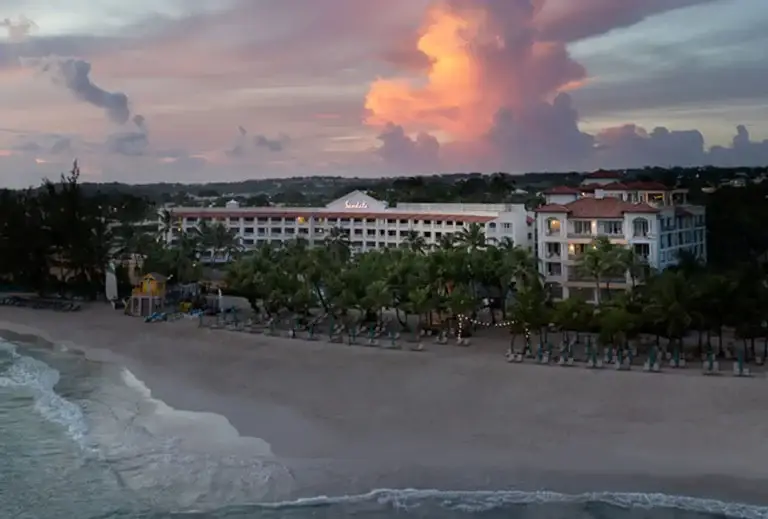 Aerial view of Sandals Barbados resort and beach at sunset