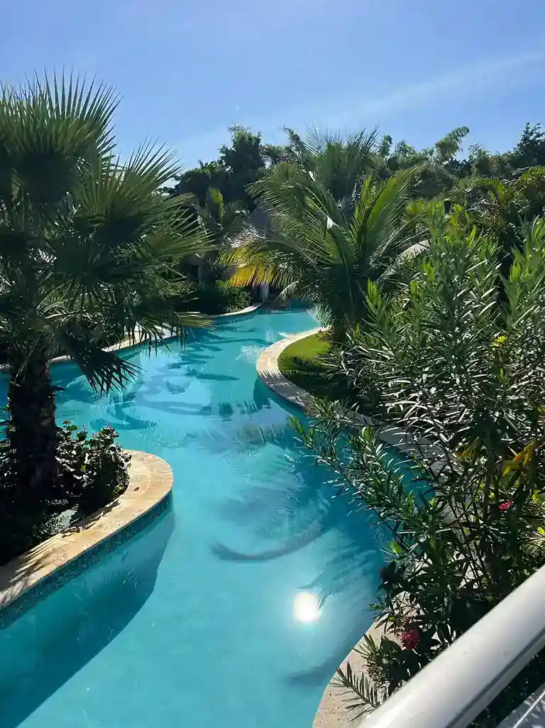 Lazy river pool surrounded by palm trees at Sandals South Coast